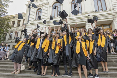Students throw their caps into the air on the steps of Ivane Javakhishvili Tbilisi State University on graduation day. It is the oldest university in Georgia and the Caucasus region.