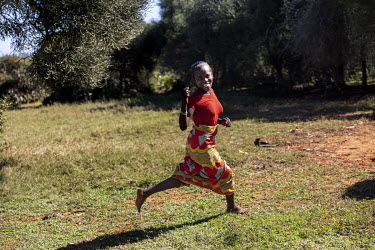 A woman runs through the village of Bekinagua.