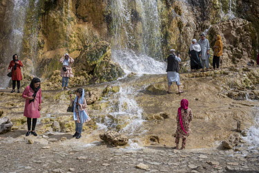 Taliban fighters and tourists beside a waterfall at one of the Band-e Amir lakes.