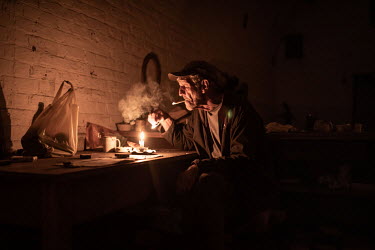 Artist Dirk Winterbach lights a cigarette in his home in former armoury building on a disused 19th century military base in the Tamboerskloof neighbourhood. The base is being occupied by dozens of fam...
