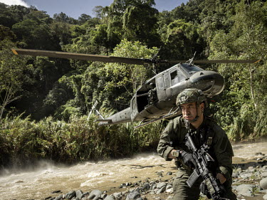 A member of a specialist anti-narcotics police force, the 'Comando Jungla', jumps out from a helicopter as they conduct a mission destroying remote mountainside cocaine laboratories. In this area, ove...