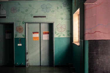 Murals and bright colours adorn the walls of a defunct elevator lobby in Cissie Gool House, an abandoned hospital that now houses over 1,000 people in the Woodstock neighbourhood of Cape Town. During...