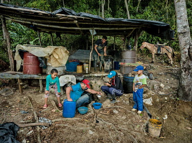 Martin Osorio (38), with his family, daughter Diney Alexandra and son Michael, and Andres Hernandez (26), working at a clandestine cocaine laboratory, during the final stage of cocaine production. Oso...