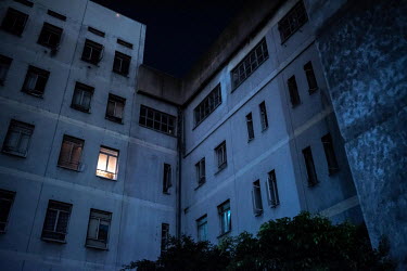 A light shines in a window of Ahmed Kathrada House, a former nursing home in inner-city Cape Town that is now home to a community of several hundred families. The building lacks electricity or running...