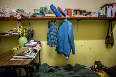 School clothes belonging to 14-year-old Akisha Arendse hang from a shelf in the room she shares with her father in Cissie Gool House, formerly the Woodstock Hospital, which has been occupied by housin...