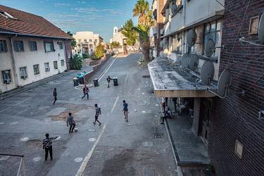 Boys play football in the car park at Cissie Gool House, an abandoned hospital now being occupied by over 1,000 squatters. Since 2017, the Reclaim the City movement has been supporting the occupation...