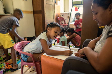 Imaan (6) does her homework with the help of her mother, Aneefah, in their room at the former Woodstock Hospital in Cape Town, which is now being occupied by over 1,000 squatters. Aneefah's family had...