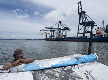 A fisherman passes the Kaltim Kariangau Terminal in Balikpapan Bay. The terminal will be used to bring in construction material to build the new Indonesian capital, Nusantara, at the northern tip of t...