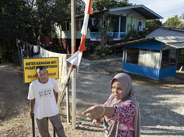 Mr Gowau and his wife Raniah stand in front of their house in Bumi Harapan. The house, which they bought in 2011, is located in the core area of the new Indonesian capital, Nusantara, that will be bui...