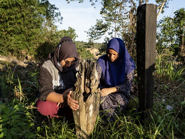 Samira and Sabardin, two women from the village of Sepaku, praying at the grave of their ancestors in the ancient cemetery of the indigenous Balik tribe. The cemetery, situated in the construction sit...