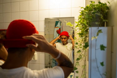Mir Reyad checks his hat in the bathroom mirror at his home before going out. Reyad is from Dhaka, the Bangladeshi capital, and has been granted political asylum in Sweden due to dangers he faced thro...