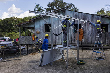 Workers, from a company responsible for the installation of photovoltaic solar panels, assembles equipment in the house of the dos Santos Alho family which is located along a creek in rural Melgaco. T...