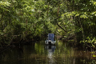 A small boat carries photovoltaic solar panels up a creek to a riverside community on Marajo Island where they will be installed providing a source of electricity. The riverside dwellers of Marajo are...