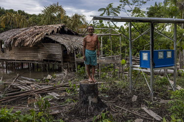 Miguel Dias Moreira (63) beside the photovoltaic panels recently installed at their home providing the family with reliable electricity for the first time. The riverside dwellers of Marajo Island are...