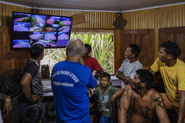 Kinja indigenous activists look at monitors displaying feeds from cameras scattered along the BR-174 highway from the Waimiri-Atroari Support Centre located on the banks of the road in Waimiri-Atroari...