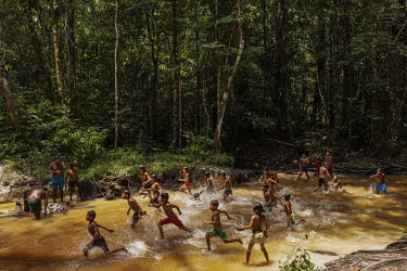 Adults and children play in a stream near Mynawa village on Waimiri-Atroari Indigenous Land during a break from a meeting held to discuss issues related to threats to their territory. The Kinjas have...