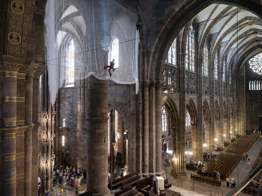 Climber Maxime Storck installs protective netting inside Strasbourg Cathedral ahead of restoration work on the dome.