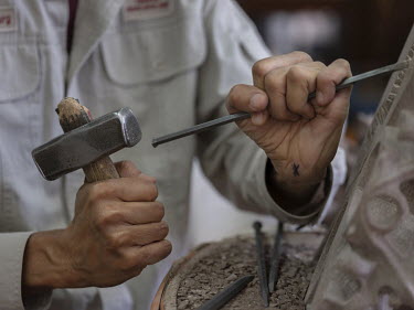 A stonemason dressing stone during Strasbourg Cathedral restoration works in a workshop of the l'Oeuvre Notre-Dame Foundation.