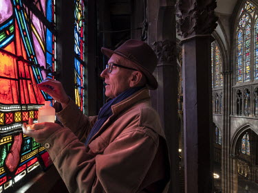 Monsieur Parot, master glassmaker, cleaning the stained glass in the south triforium of Strasbourg Cathedral.