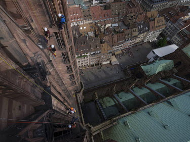 Thierry Bastian, Boris Debourbe and Aymeric Zabollone, stonemasons from the Oeuvre Notre-Dame Foundation, climbing the outside of Strasbourg Cathedral during a rope access training course.
