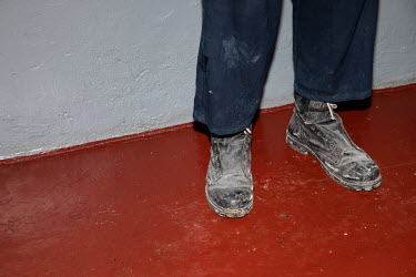 A Russian prisoner of war at a detention facility wearing boots from which the laces have been removed.