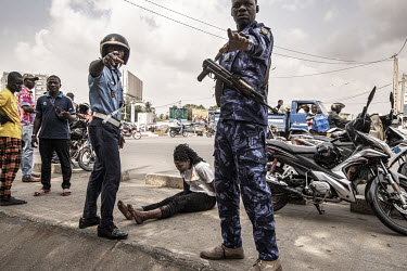 Police attend the site of a motorcycle accident, where, following a particularly distressing collision on Togo's coastal highway, a woman cries out with pain after being knocked off her motorcycle, he...