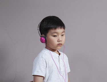 A portrait of Kim wearing a pair of pink headphones. Stitched photograph
