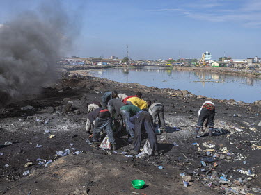 People collecting recyclable waste at the Agbogbloshie dump, the world's largest electronic waste site. Thousands of people, among them large numbers of minors, live by dismantling and burning electro...