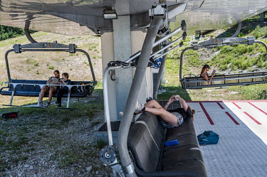 Tourists use the ski lifts to read in the shade during the summer off-season.The Alps have long been known for their winter tourism, but in recent years, there has been a push to attract tourists in t...