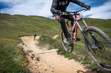 Mountain bike riders careen down a path in the summer season.The Alps have long been known for their winter tourism, but in recent years, there has been a push to attract tourists in the summer as wel...
