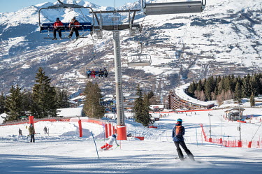 Ski lifts transport tourists up a snow covered slope so they can ski back down soon after.
