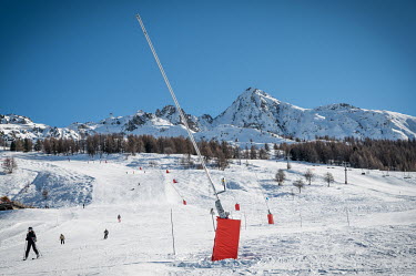 Snow lances which are hardly noticeable in the winter season line a ski slope.