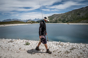 Luc Mauduit (36) fly fishing for trout released in to the reservoir that supplies Arc 2000 with water for its artificial snow during winter. Luc no longer comes to the ski area in the winter because h...