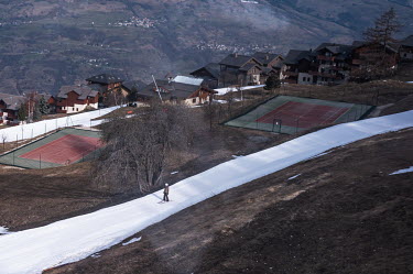 A tourists skiing past in a resort.The impact of global warming is becoming increasingly evident, as seen in the drop in snowfall levels in the Alps. On average, snowfall levels have decreased by 64 c...