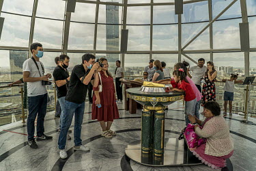 In the panoramic room installed at the top of the Baiterek tower, children place their hand in the palm print of the First President Nursultan Nazabayev, engraved in a two kilo solid gold plate. The e...