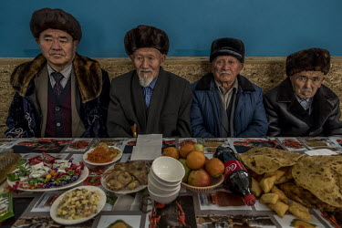In the gymnasium of the Beinetkech school, Kaldybay (92), Ergech (85), Kalmakan (86) and Kuttybay (92), the elders of the village, are waiting for the beginning of a village meal that gathers the whol...