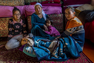 The ^Qandas^ family of Zukhra Mukanova (blue scarf) in the living room of the family home. The term ^Qandas^ literally means (of the same blood) and has replaced the word ^Oralman^ previously used for...