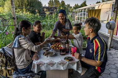 In the dacha district of Prigorodny, in a suburb of Astana close to the airport, a family and friends are having dinner. 10,000 to 15,000 people, or 2,500 families, live in the district during the sum...
