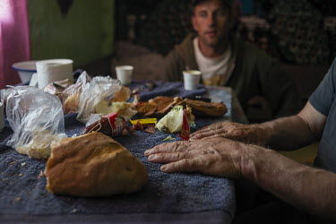 Villages eat a simple lunch of bread and sausage.High in the mountains above Poienile de sub Munte, said to be Romania's largest village, is an unnamed community of smallholders that some callDardila'...