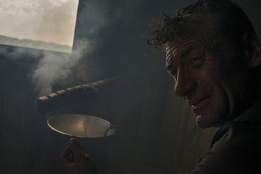 A shepherd preparing food in a hut.High in the mountains above Poienile de sub Munte, said to be Romania's largest village, is an unnamed community of smallholders that some callDardila's Hill, after...
