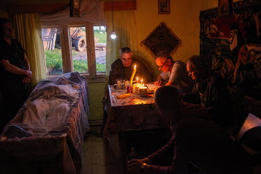 Men read the last rites during the funeral service of Ghibus Miron (82) at the dead man's house in the remote mountains of northern Romania near the border with Ukraine.High in the mountains above Poi...