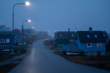 Mist shrouds houses lining a road in Ilulissat.