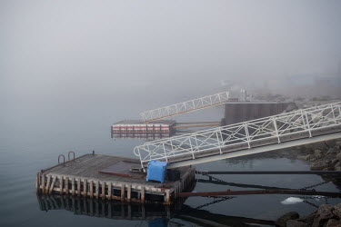 Mist shrounds a pair of small floating pontoon jetties the town's harbour which is seeing an increase in tourism by cruise ship, as waters become less clogged with ice in summer and even winter.