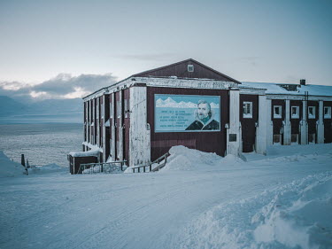 A mural of a typical Soviet polar explorer adorns the facade of a former canteen. On it is a poem about the Arctic by the Russian writer Robert Rozhdestvensky: ^Wherever you wander now, on the thresho...