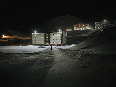 A lone figure walking outside in the Arctic silence in the four-month-long polar night when there is a constant danger of being attacked by polar bears.