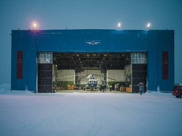 An Mi-8 helicopter in a hanger. The aircraft acts as a lifeline for the people of Barentsburg. Because of the unpredictable weather it is a dangerousplace to fly. A team of pilots, engineers and groun...