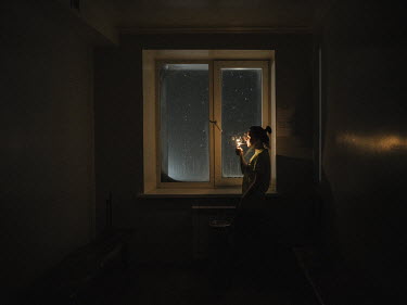 A woman lights a cigarette. High levels of smoking are encouraged by cheap cigarettes imported from Russia.