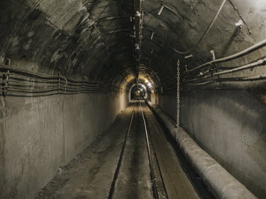 A train tunnel that takes miners down to around 500 metres below the surface. The mechanised mining processes and safety measures, as well as the operation of the lorries used to take the coal away, r...