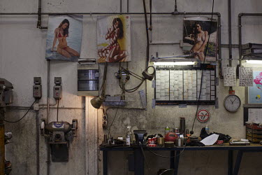 Posters of women in swimsuits on the wall of a boat repair workshop in Torshavn.