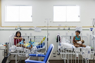 Young Yanomami mothers hold their children, hospitalised with severe malnutrition, in the infirmary of the Santo Antonio Children's Hospital. President Lula's government declared a state of public hea...